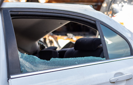 Criminal incident. Breaking into a car parked on the street. Broken side glass and the passenger compartment behind it. A crime committed by a thief, stealing things. Car after an accident.